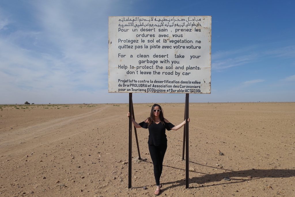 Pilar with a warning sign not to trash the desert, on the way to Erg Chegaga