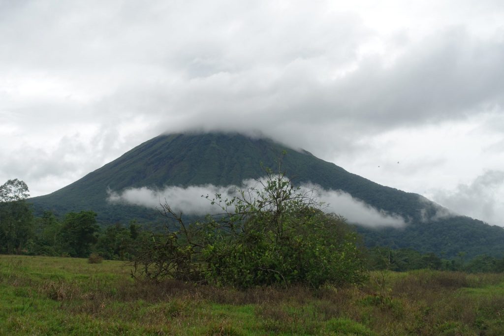 A view of the Arenal volcano with clouds on the top