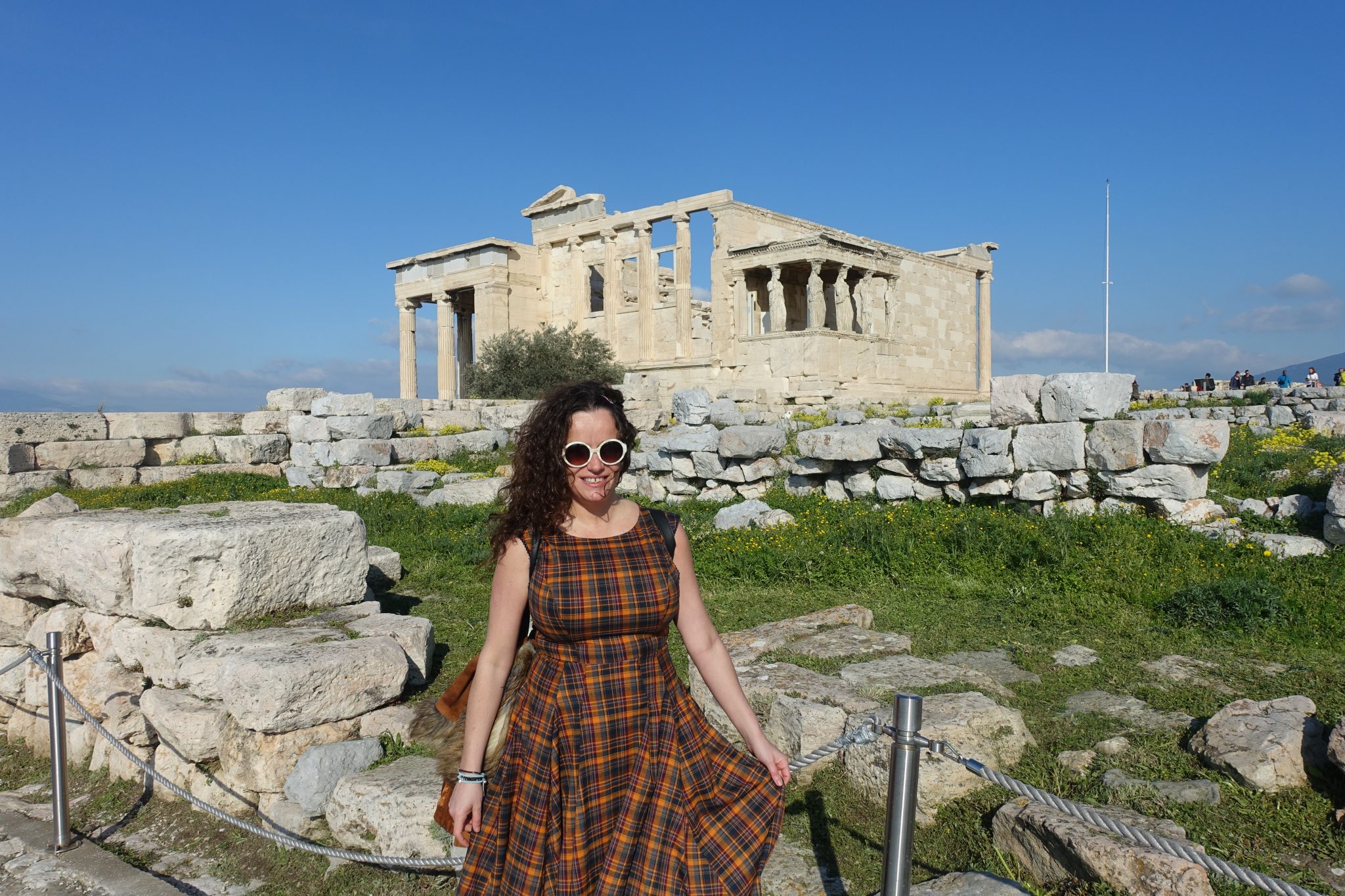 Pilar and a view of the Caryatids building on the back in the Athens Acropolis on a sunny day