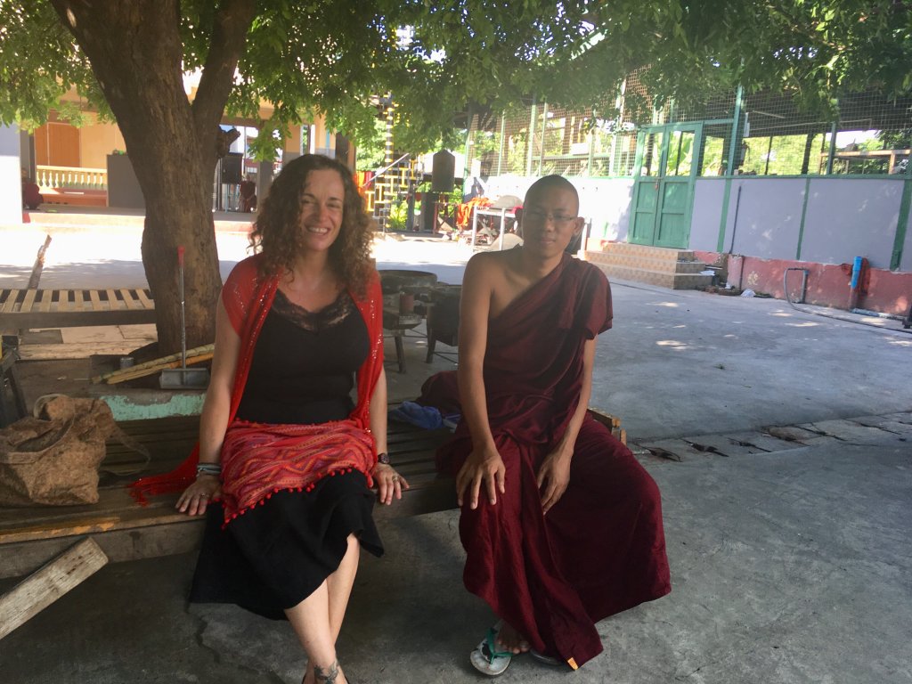 Pilar dressing up with the traditional Burmese dress sitting with a Buddhist monk