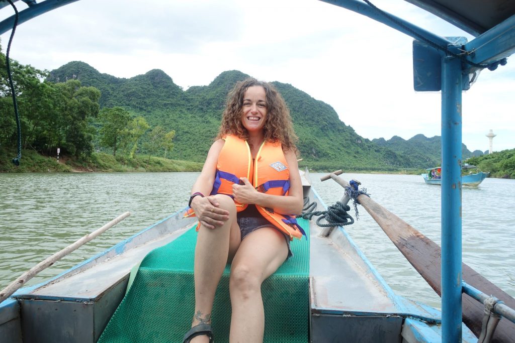Pilar sitting on the from of the boat wearing an orange life jacket. During the trip to Phong Nha cave.