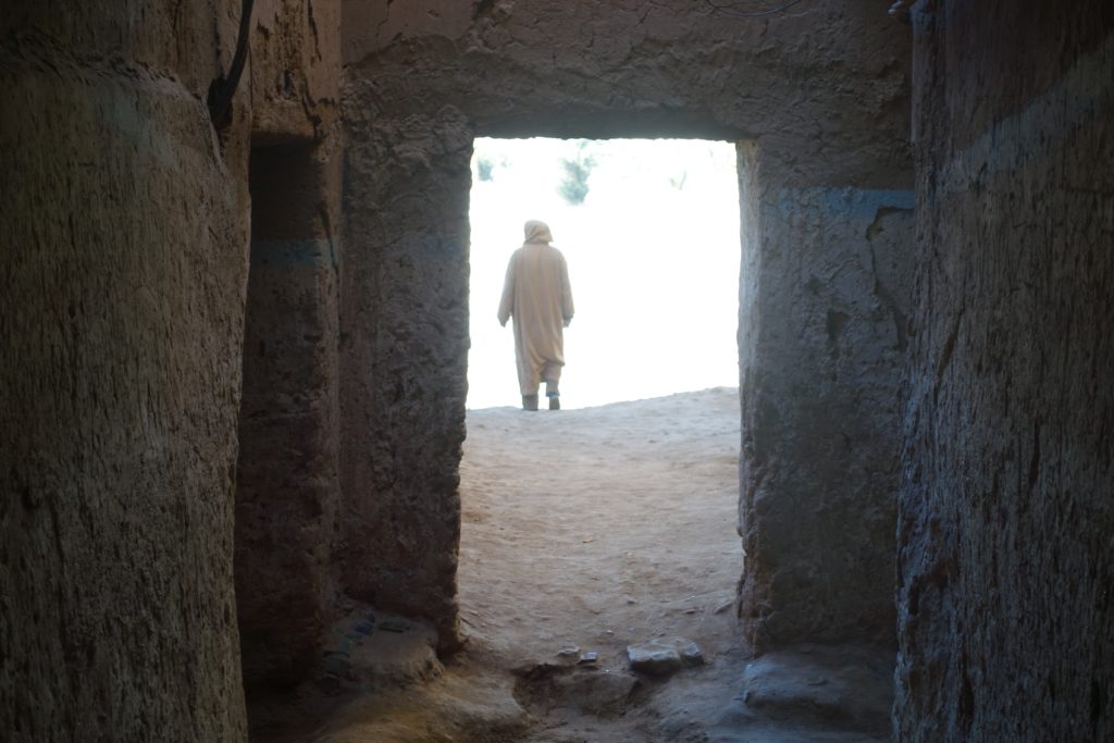 Tamegroute Kasbah and man walking from behind