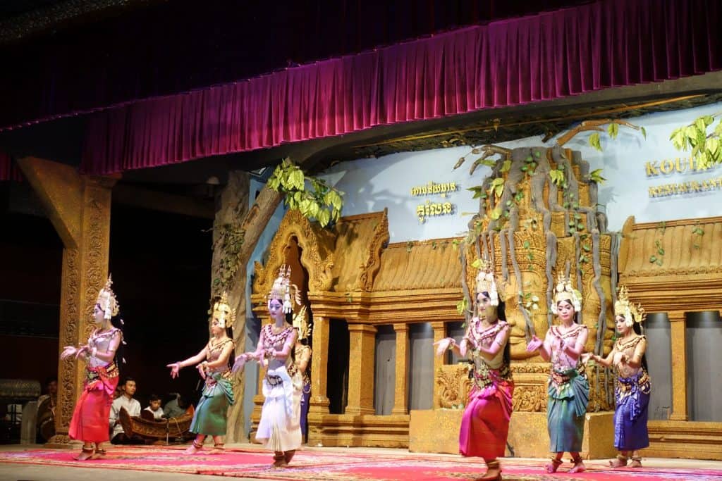 Apsaras dancing at the show on the stage. They are wearing the typical apsara oufit with golden hat and colorful dresses.