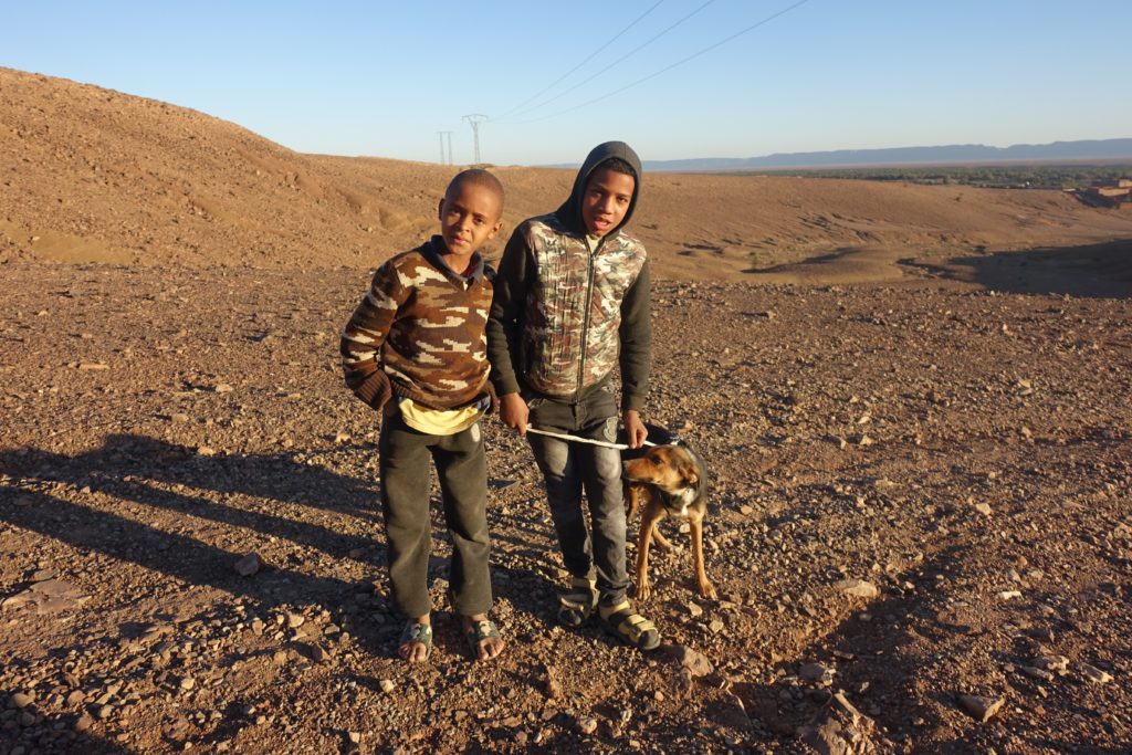Moroccan children with a dog on the way to Jbel Zagora