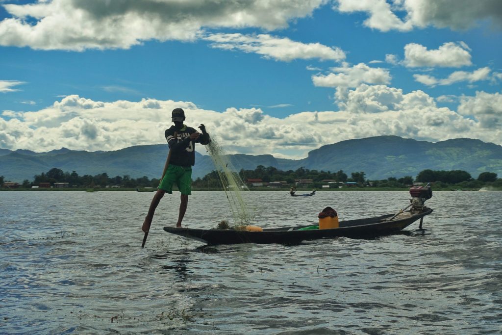 Fishermen rowing with the leg at Inle lake