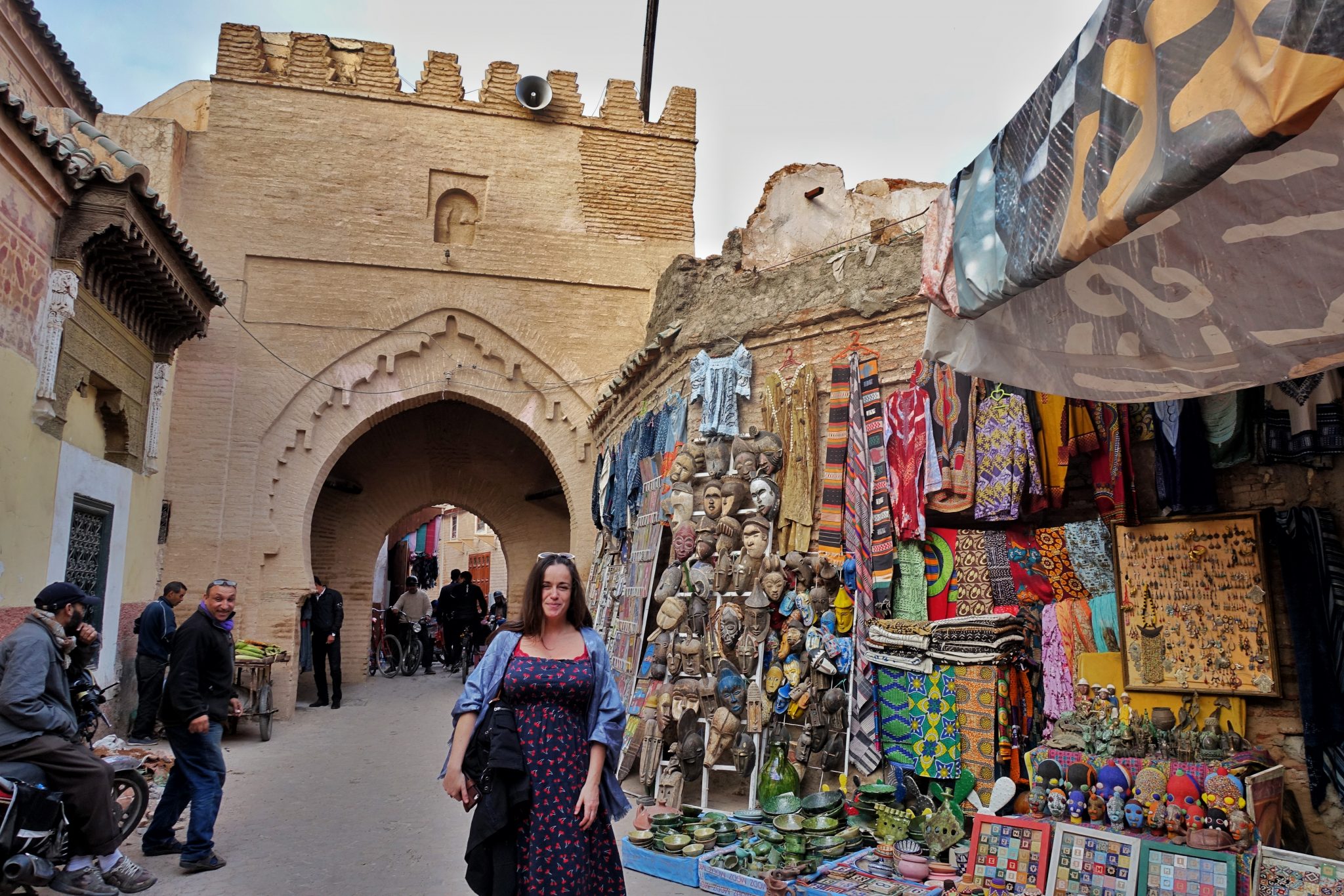 Pilar at the Marrakech old Medina and some colorful stalls selling clothes and African carved statues