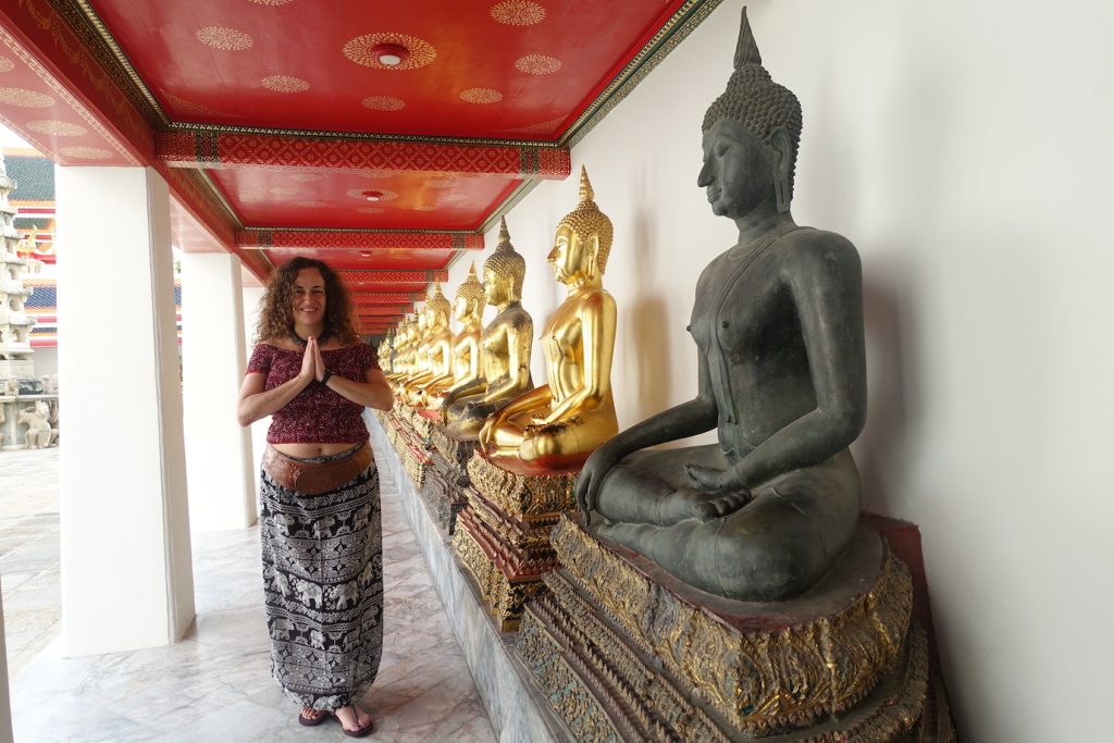 A row of Buddhas at Wat Pho temple in Bangkok and Pilar in prater postion