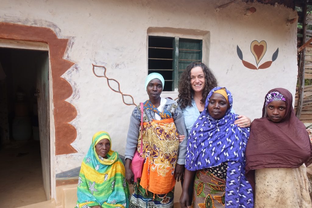 Pilar with with four Shambaa women at the entrance of a traditional Shambaa house in Mambo village in Tanzania. The house wall has a painting of a heart on the wall.