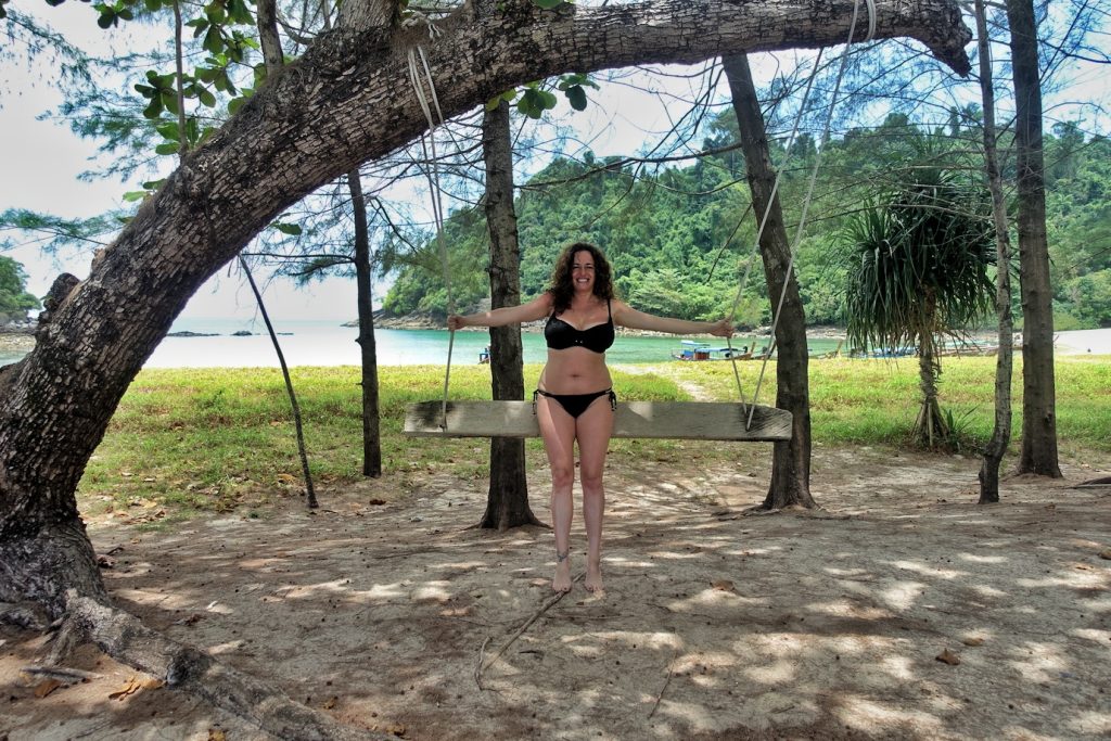 Pilar sitting on a swing hanging on a tree at Mu Koh Kam beach