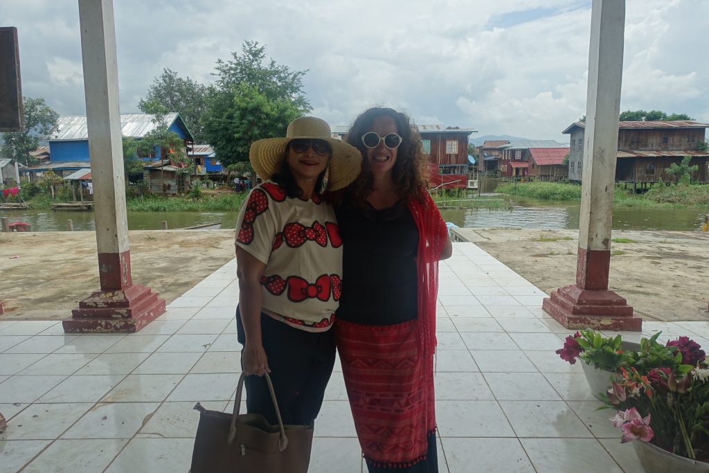Pilar and a Burmuese woman posing at the entrance of a Buddhist temple in Inle lake