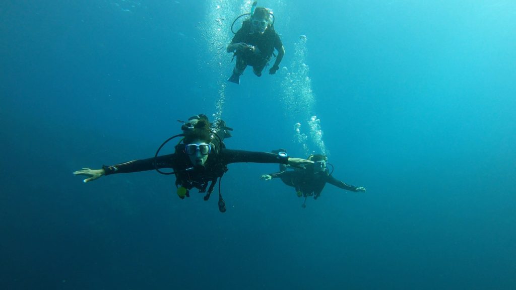 Three divers flying over the Dahab Blue Hole