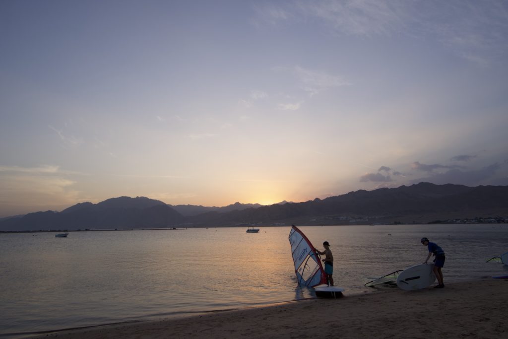 A couple of windsurfers a Lagoona beach in Dahab, during sunset time