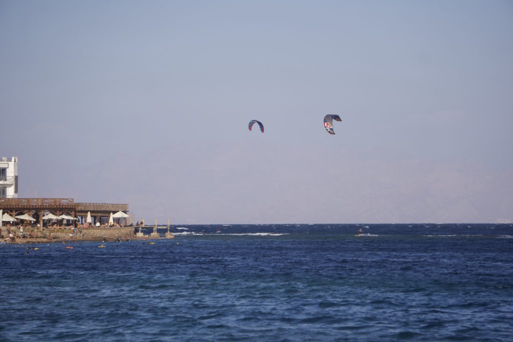 A view of Dahab coast with some kite surfers and coast of Saudi Arabia on the horizon