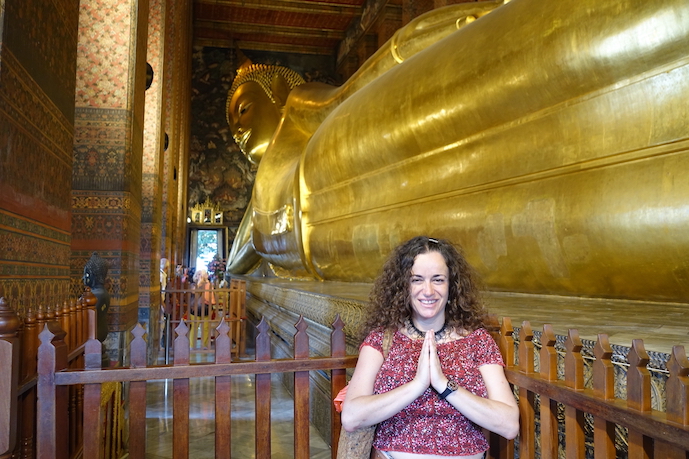 Pilar in prayer position and the giant golden reclining Buddha on the back