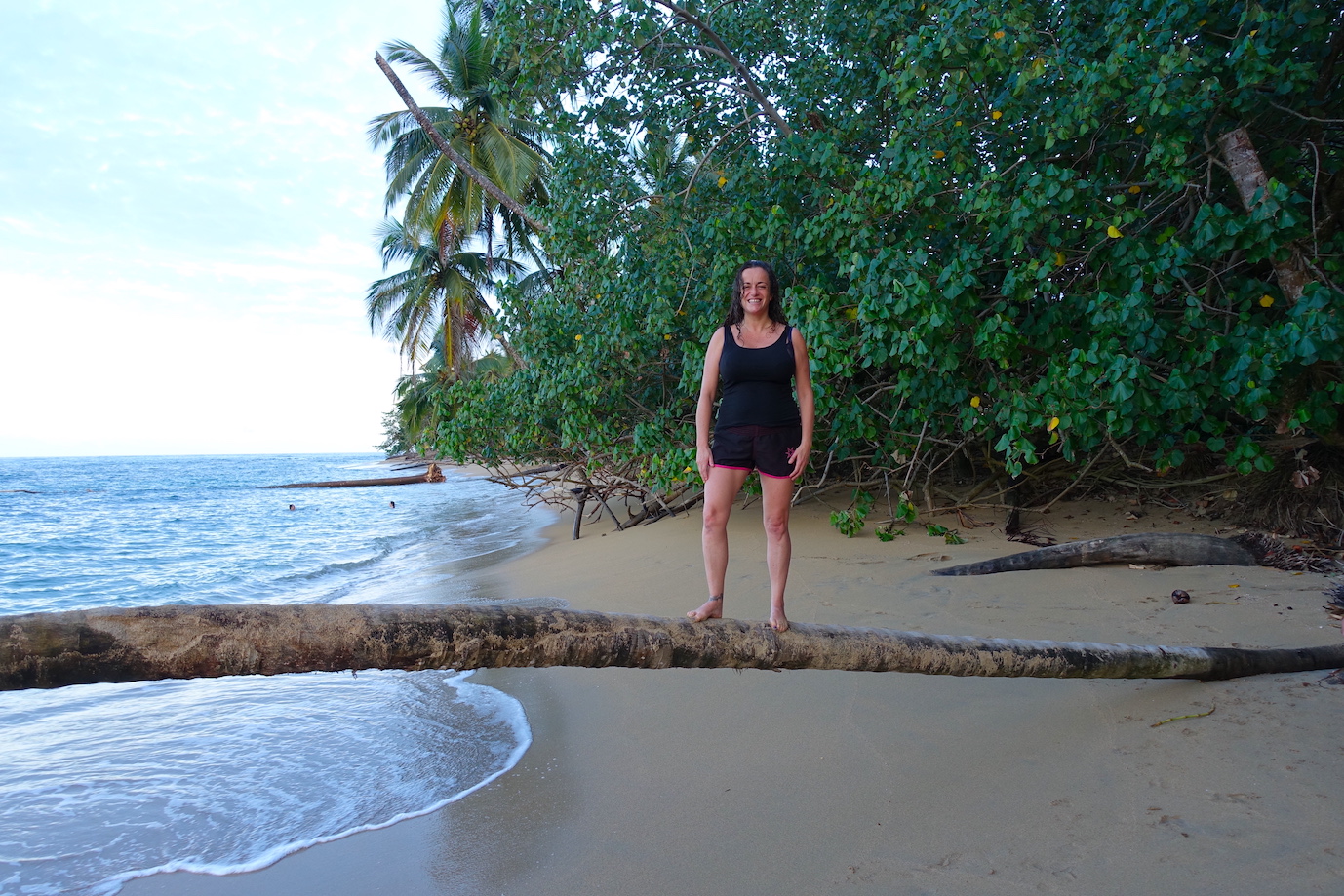 Pilar standing on a palm tree in Punta Uva beach in Puerto Viejo