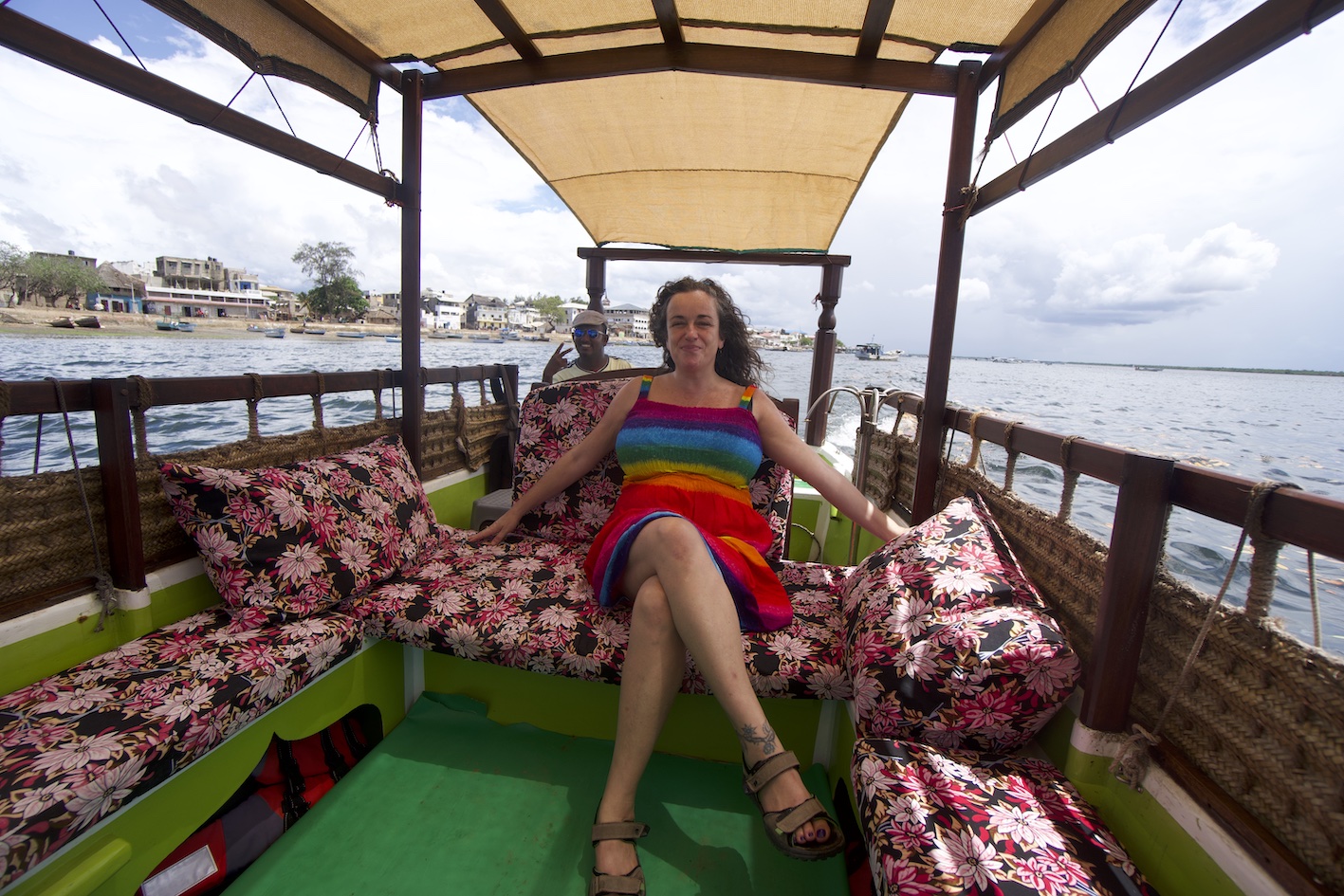 Pilar on a boat around Lamu island with a rainbow dress