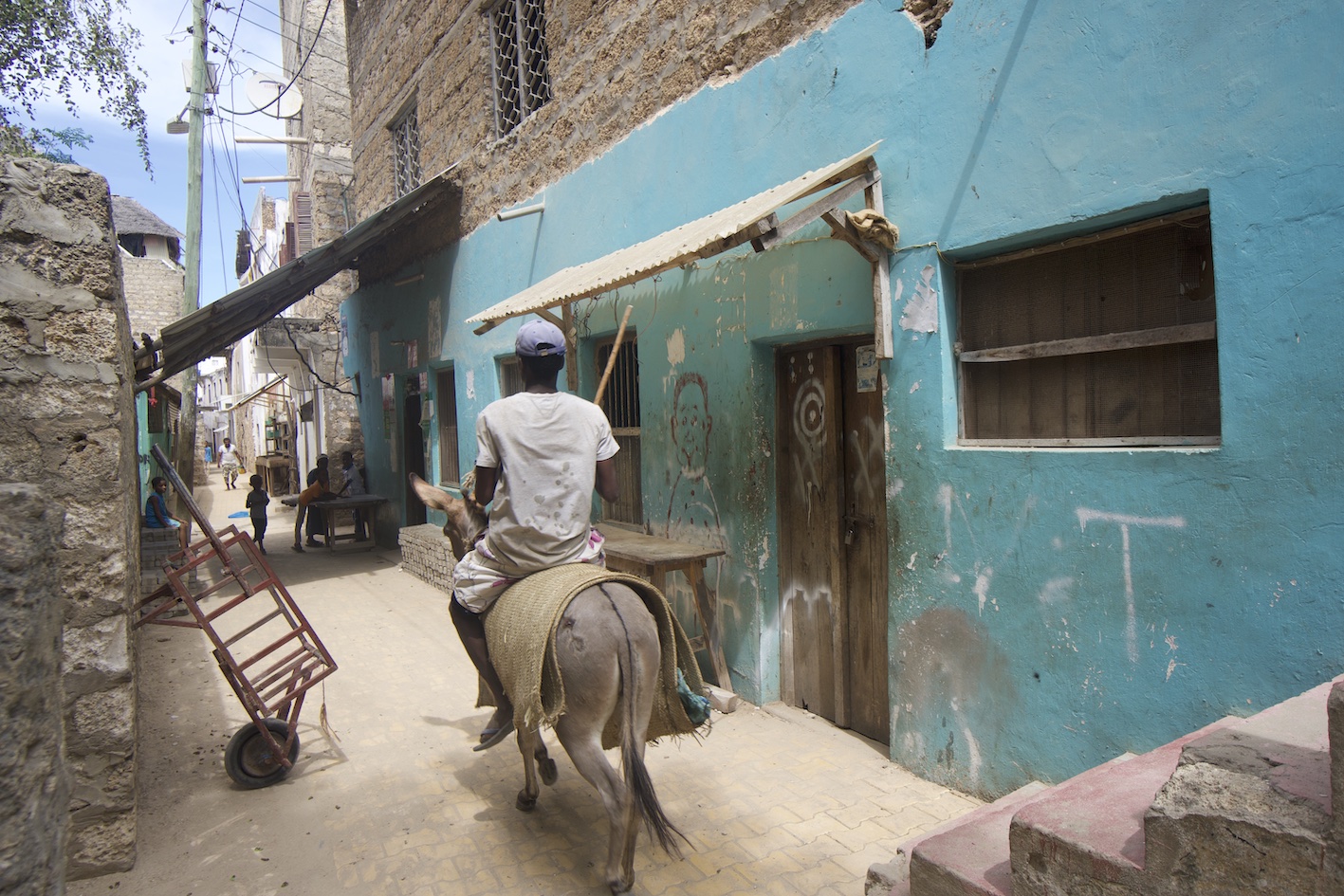 Man from behind riding a donkey in Shela village