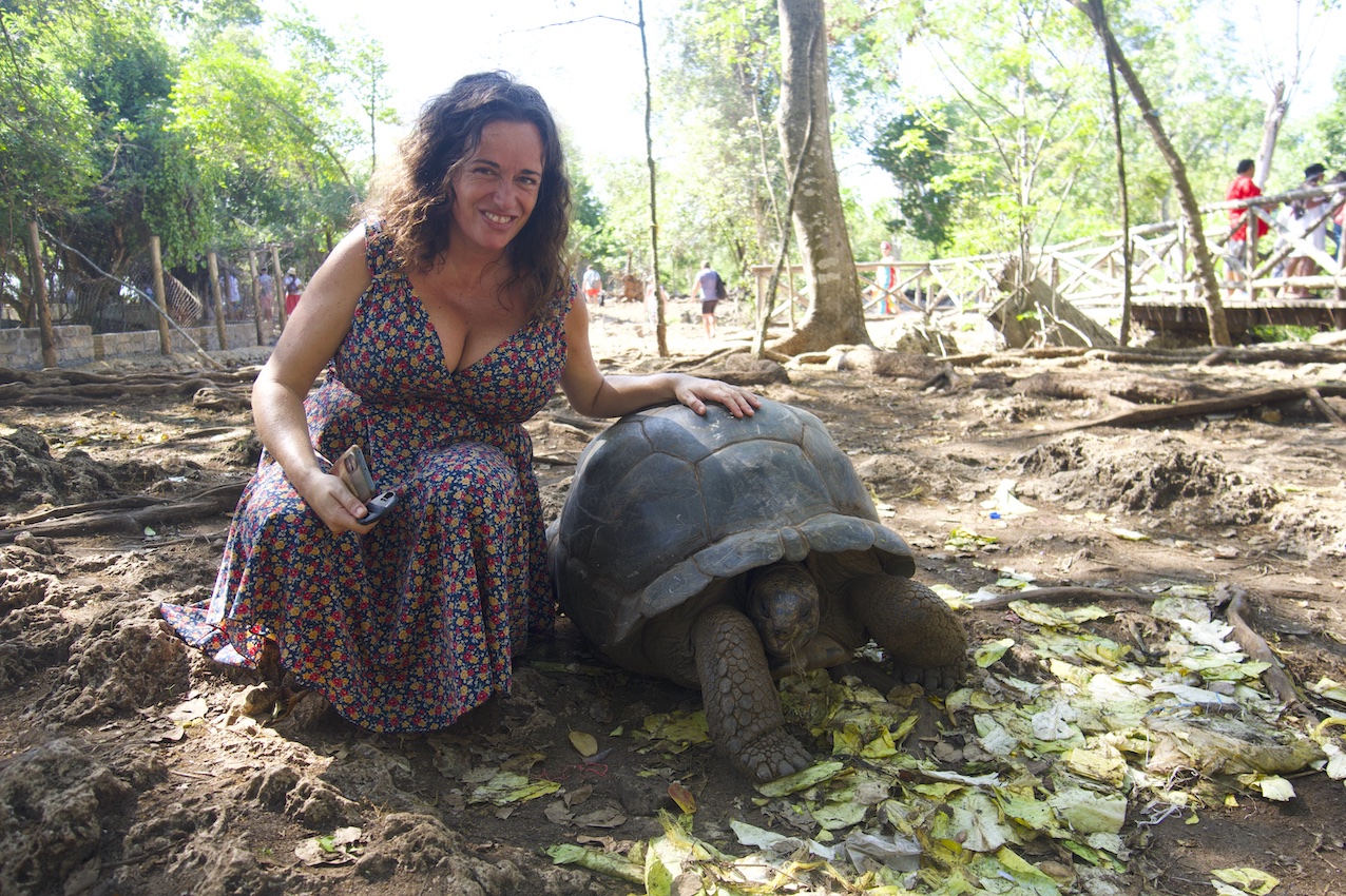 Pilar sitting on the floor with an Aldabra turtle