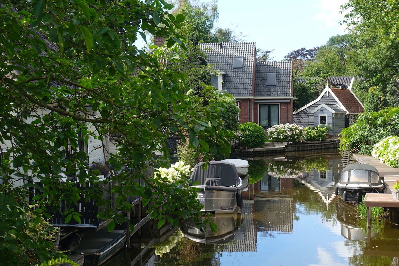 A stunning view of a canal in the Amsterdam countryside, in Broek in Waterland. Water reflections of houses and boats