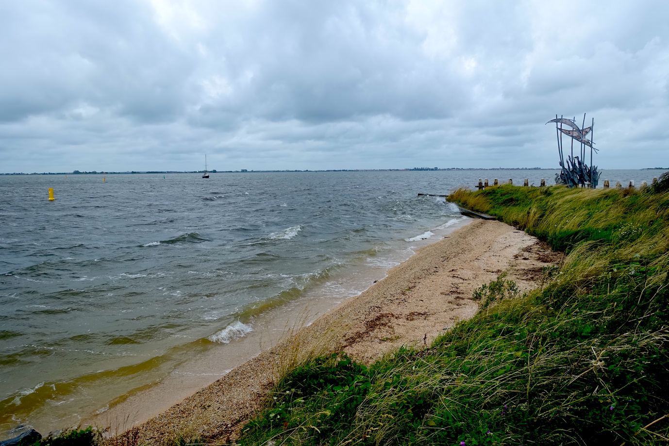A view of the Marken beach close to the harbor and an art sculpture