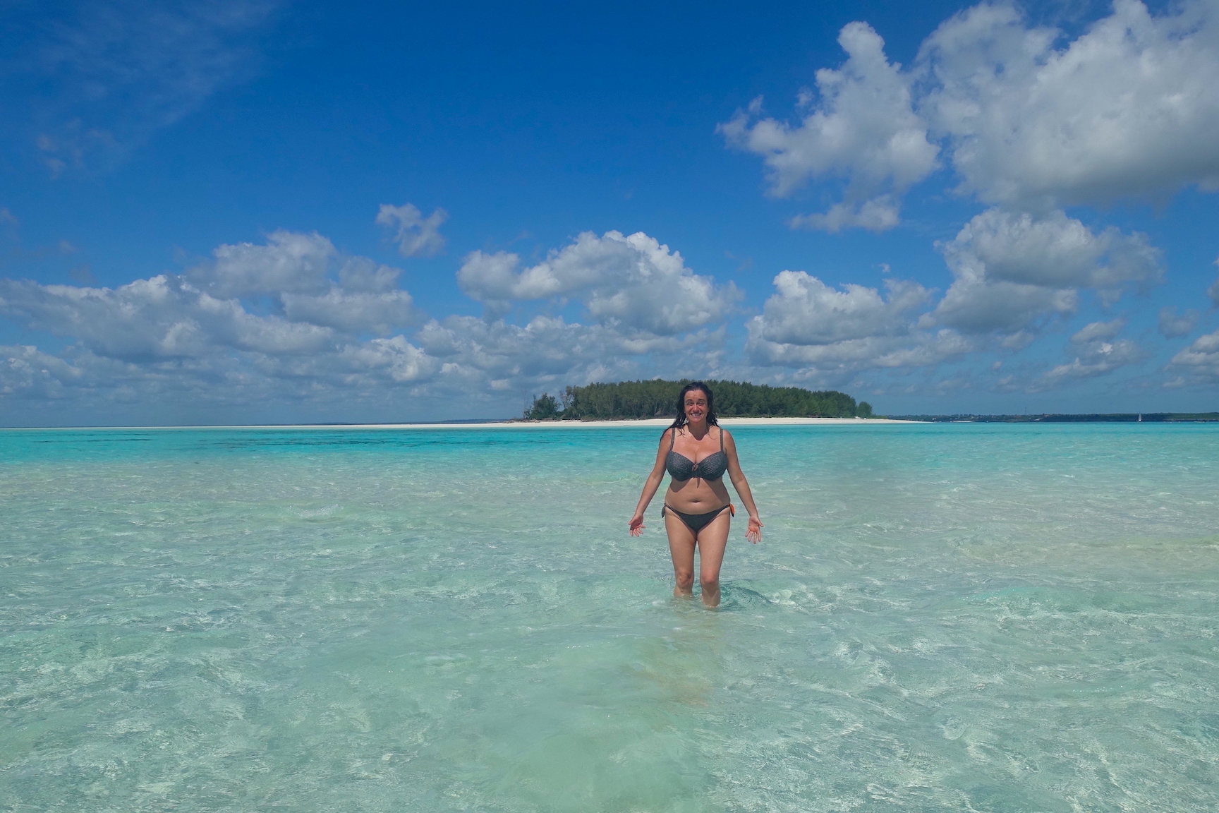 Pilar on the beautiful transparent blue water around Mnemba island and the island on the back