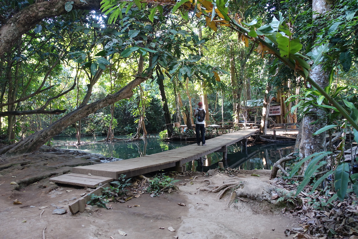 A bamboo bridge crossing a pool on top of the Kunag Si waterfalls