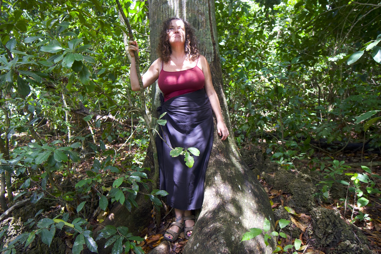 Pilar with a tree receiving the sunlight on her face on the Diani sacred forest