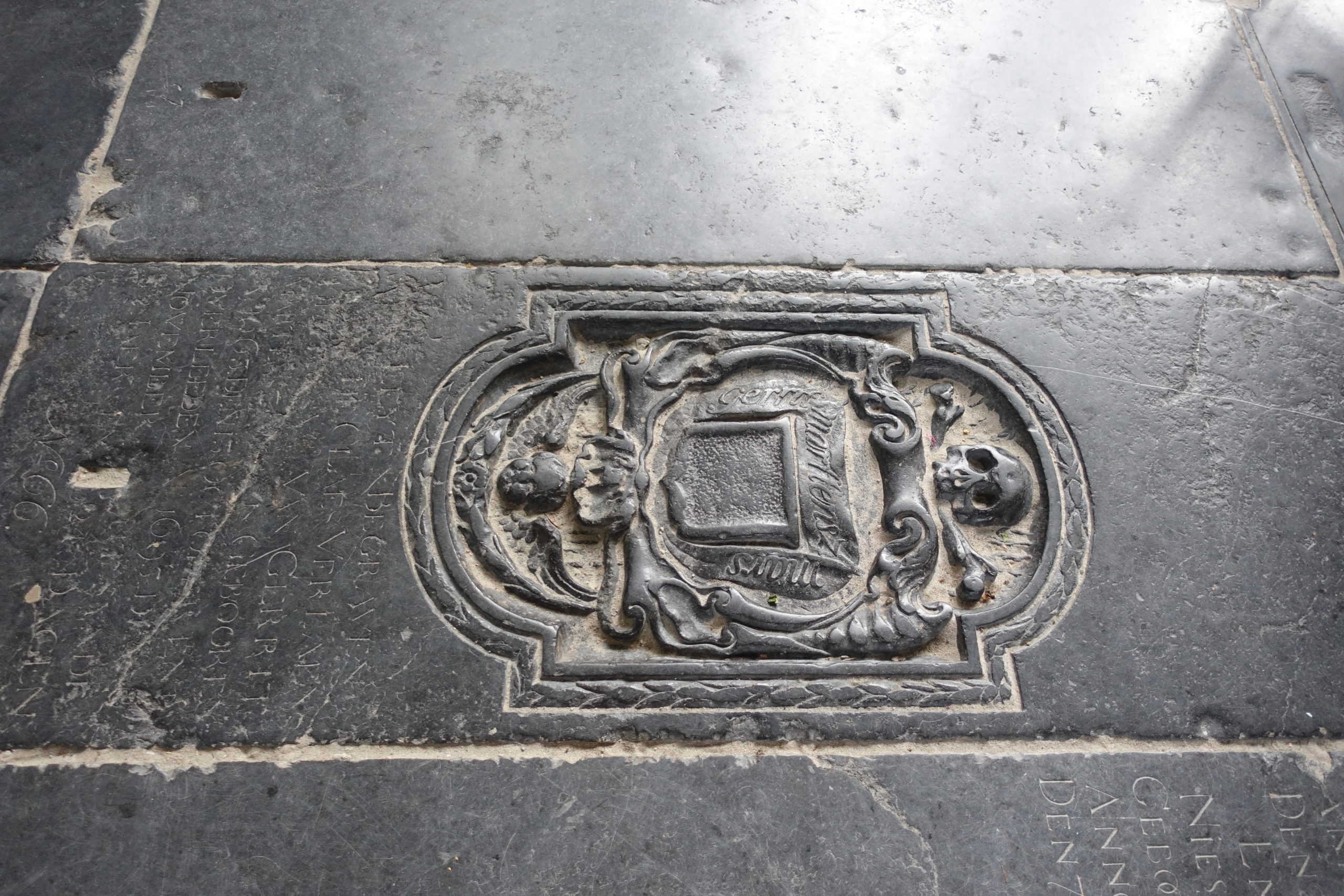 A black grave with a skull with a coat of arms in the Broek in Waterland church