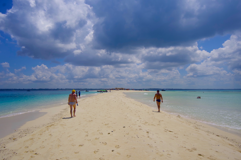 People walking in the Nakupenda beach sandbank island in Zanzibar and some clouds on the sky