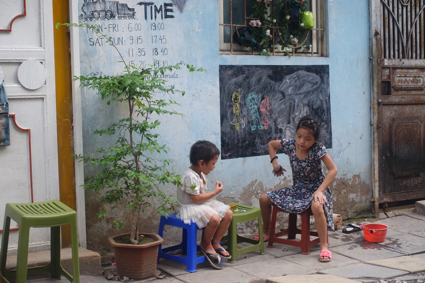 Two children at the door of a house in Hanoi Train Street