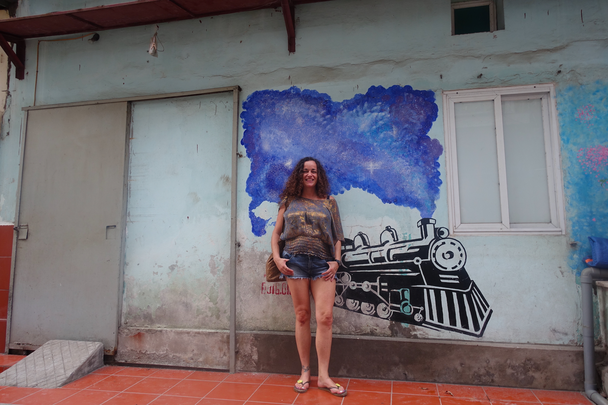 Pilar posing with train wall graffiti at Hanoi Train Street