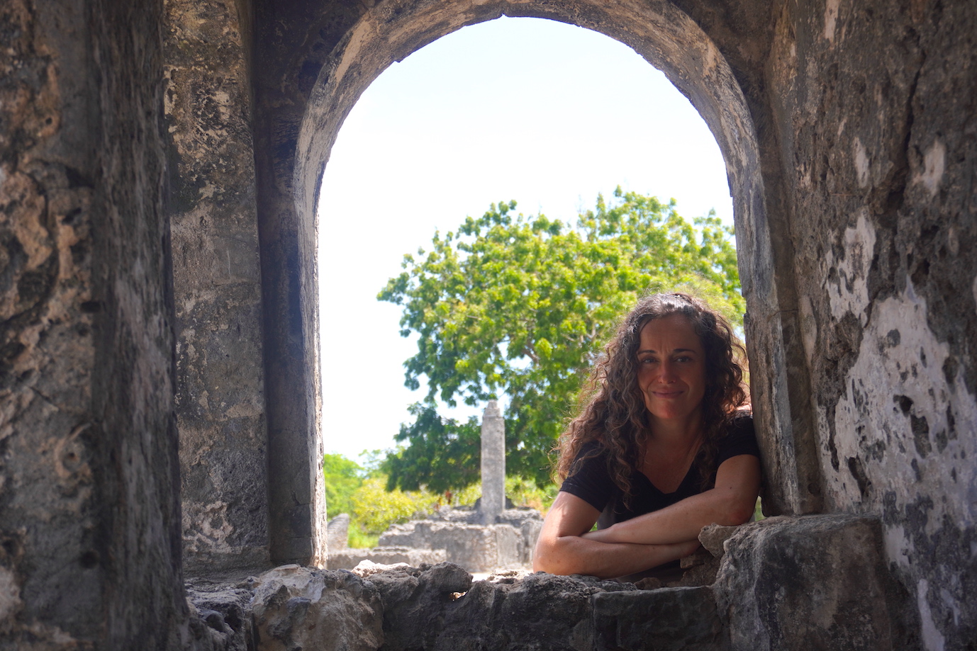 Pilar posing on an arch at the Kaole ruins in Tanzania