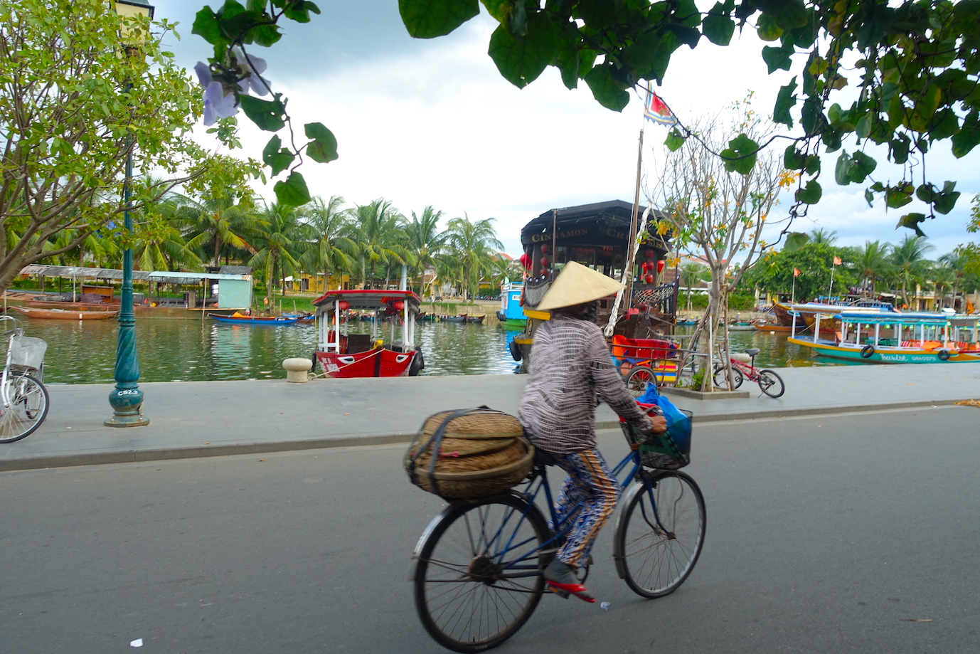 Vietname lady ciclying on the Hoi An waterfront