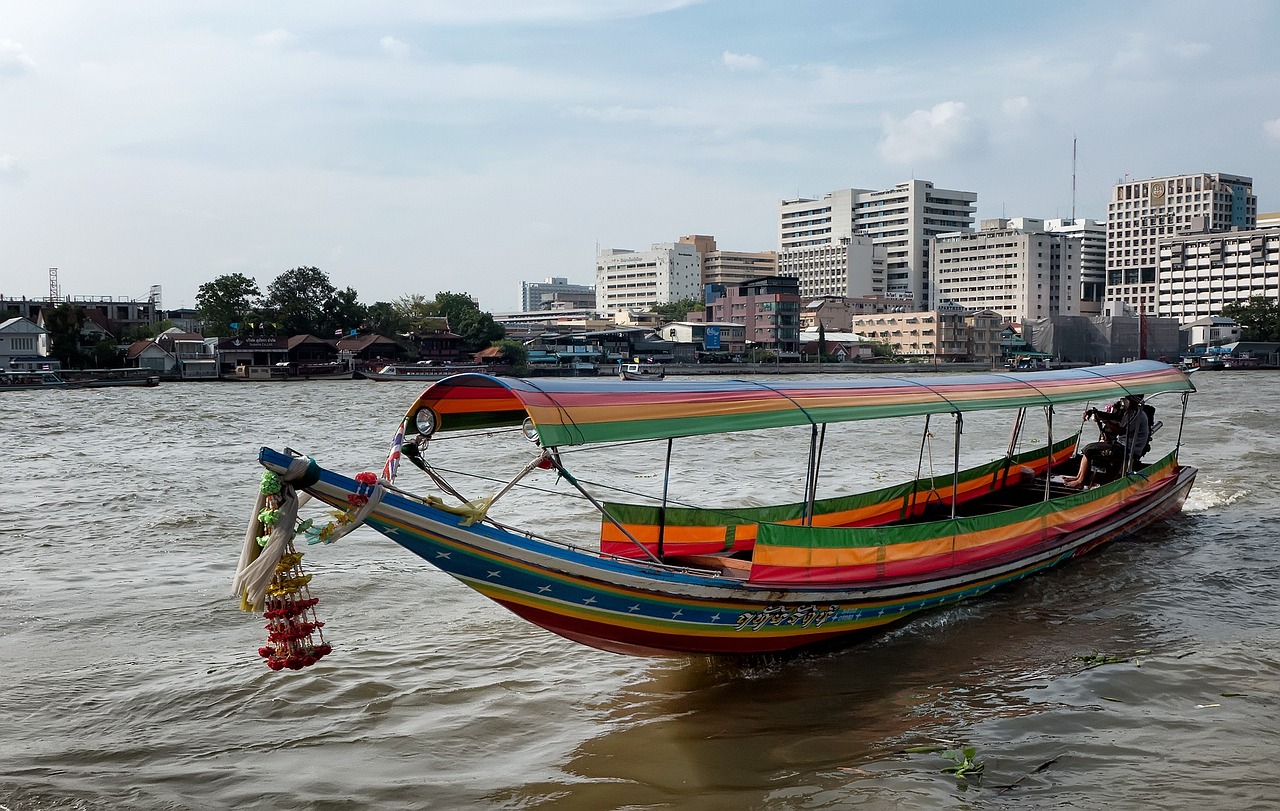 A long tail boat and some building on the back in Bangkok