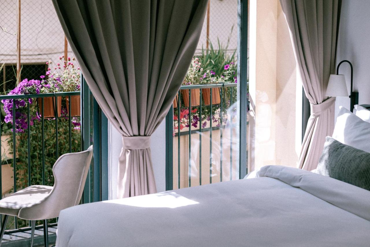 A view of the half bed and the window with some flowers at La Chronique hotel in Phnom Penh
