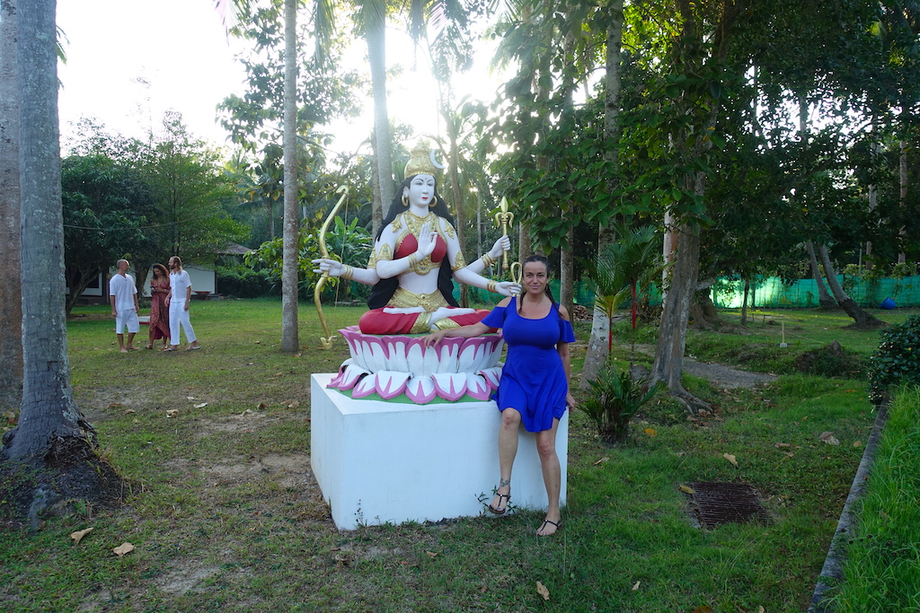 Pilar close to a goddess statue with a blue dress in the Agama yoga garden in Koh Phangan