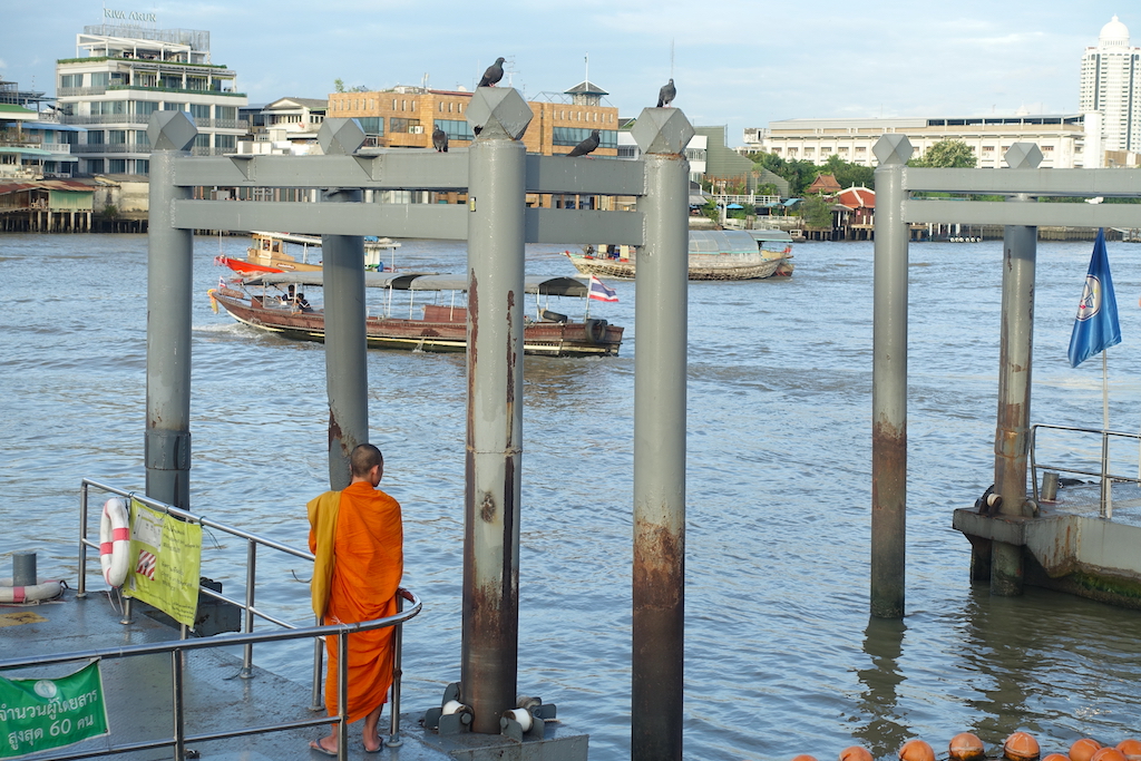 A view of the Wat Arun temple pier and a Buddhist monk from the back