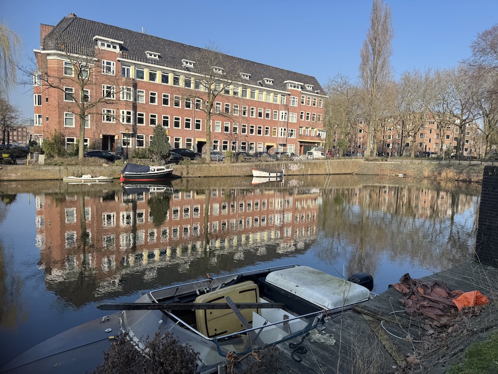 Reflections of a house in a canal in Amsterdsam