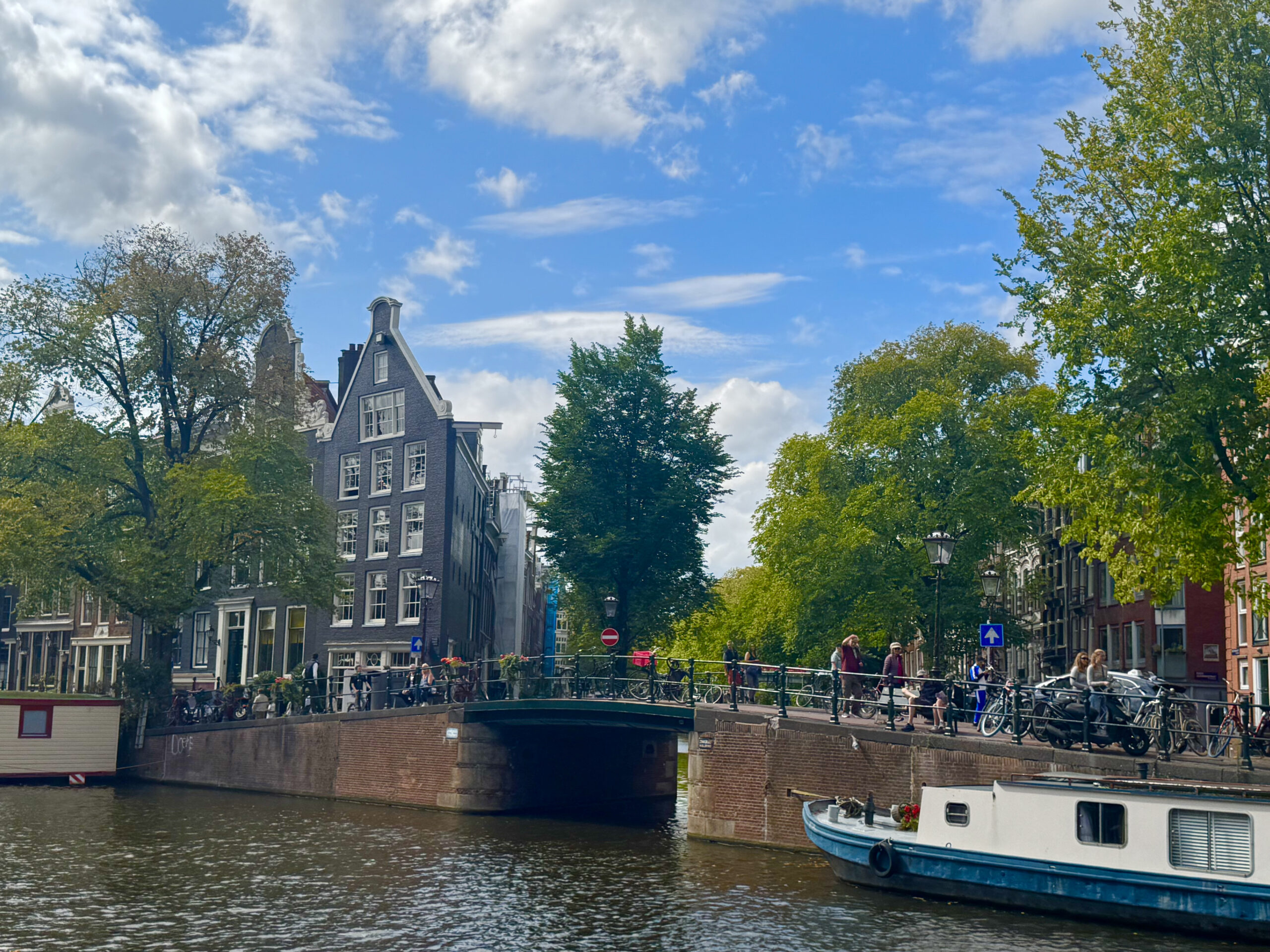 Amsterdam canal with houseboats and historic buildings reflected in the water