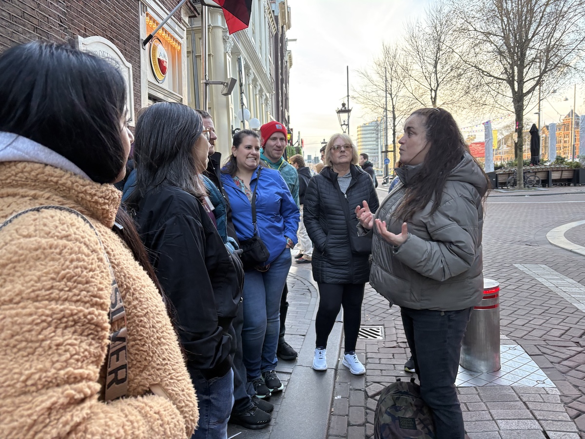 Local guide leading a walking tour group in Amsterdam city center