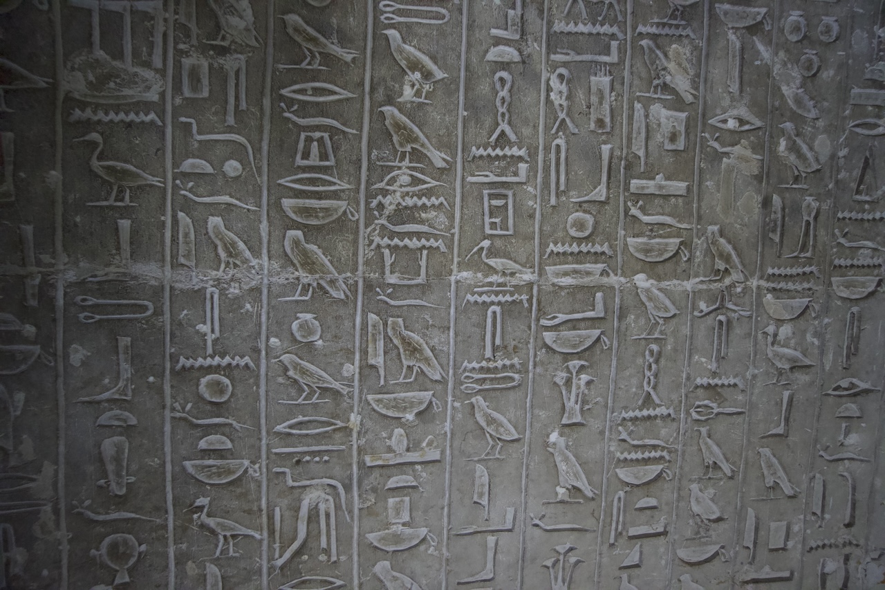 Ancient Egyptian hieroglyphs carved on wall in Saqqara tomb