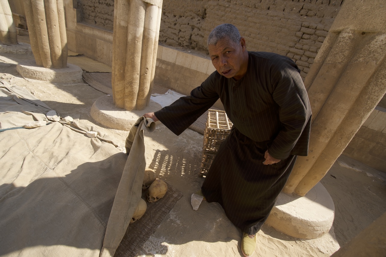 Local worker opening ancient sarcophagus in Saqqara tomb