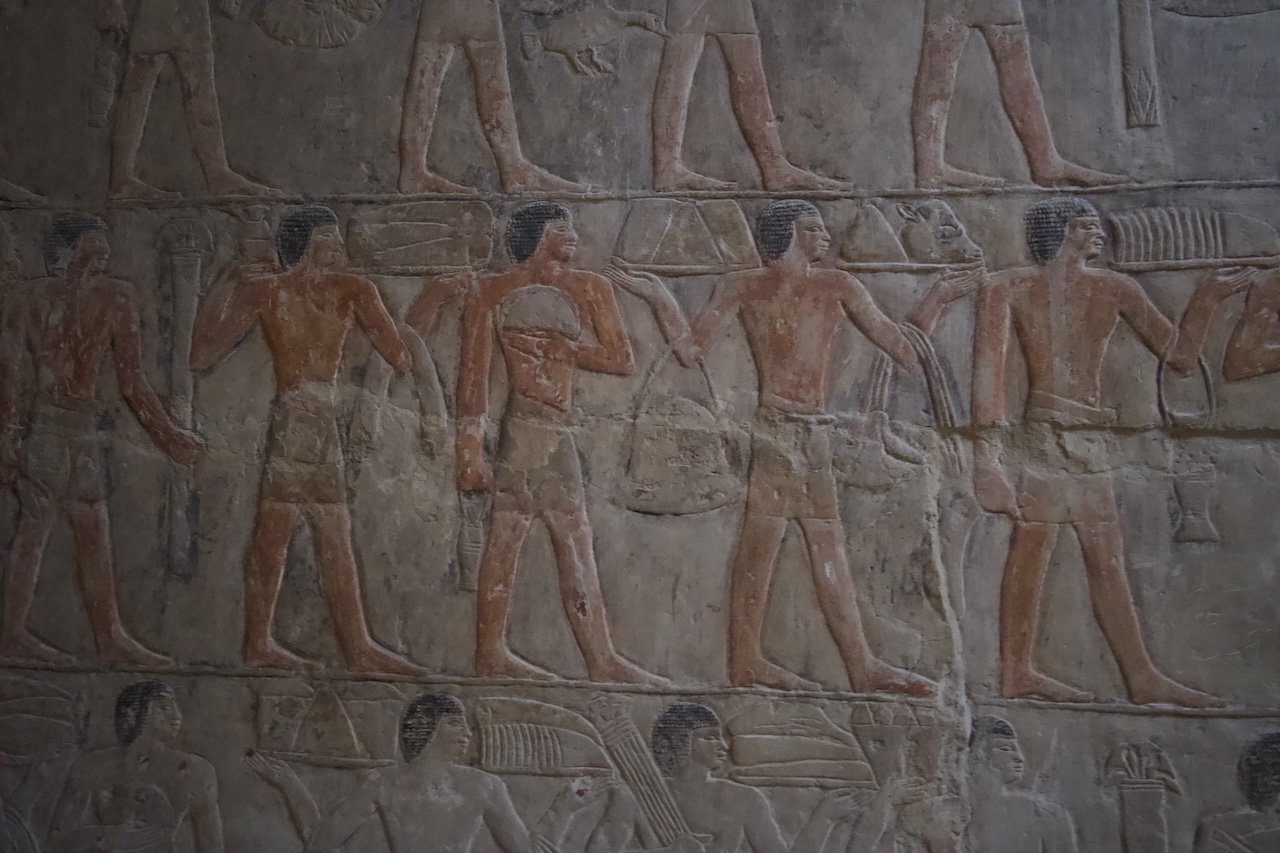 Ancient Egyptian wall paintings of figures inside Saqqara tomb