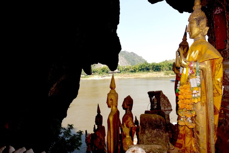 Golden Buddha statues overlooking the Mekong River from Pak Ou Caves near Luang Prabang, Laos.