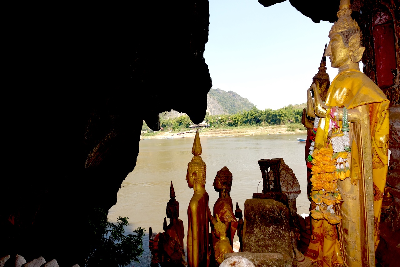 Golden Buddha statues overlooking the Mekong River from Pak Ou Caves near Luang Prabang, Laos.